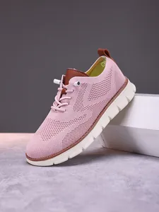 Detailed macro shot of pink breathable mesh fabric and brown pull tab on casual loafer