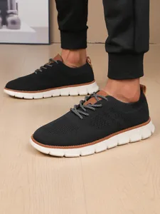 Detail of men's breathable black flyknit loafers with thick white soles on wooden floor