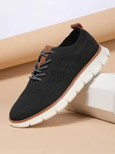 Close-up of breathable black knit mesh upper and brown leather trim on casual men's loafers