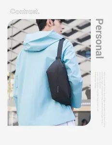 Outdoor shot of a minimalist black sling bag for men with adjustable shoulder strap