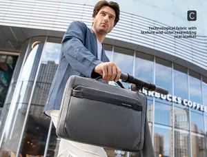 Businessman carrying a charcoal grey tech fabric laptop bag in a modern city setting