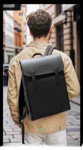 Detail of Mark Ryden waterproof black backpack with buckle flap on urban male model
