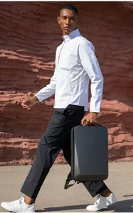 Hard shell business backpack in matte grey finish held by a model in casual wear