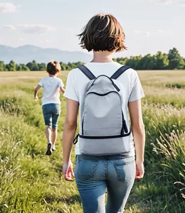 Rear view of a light grey casual backpack on person outdoors with water-resistant fabric