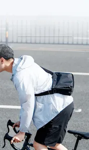 Close-up of lightweight black Oxford fabric crossbody bag worn by a cyclist during commute