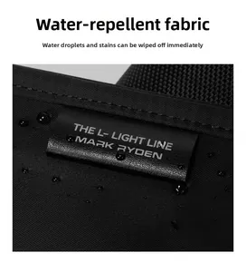 Close-up of water-repellent oxford fabric with clear water drops and Mark Ryden brand tag