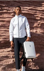 White hardshell slim laptop backpack shown with minimalist outdoor windbreaker jacket