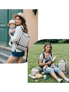 Light gray multi-functional diaper backpack with baby essentials on a green lawn