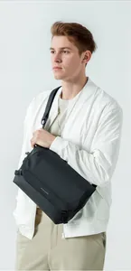 Detailed side view of Mark Ryden black crossbody bag with adjustable nylon shoulder strap