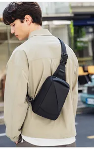 Rear view of a black Mark Ryden waterproof sling bag with adjustable strap on a male model