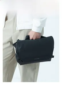 Close-up of a matte black waterproof crossbody bag with an adjustable shoulder strap