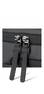 Close-up of durable dual YKK zippers on black nylon shoulder bag with matte pullers