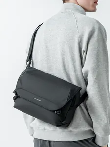 Men's black flap crossbody messenger bag shown on model with wide nylon strap