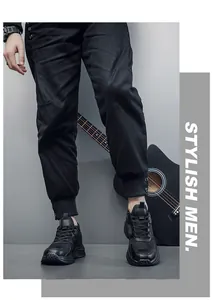 Close-up of stylish men's black sneakers with mesh leather texture on grey studio background