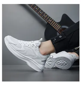 Detailed view of white breathable mesh sneakers with JGAK logo on black joggers