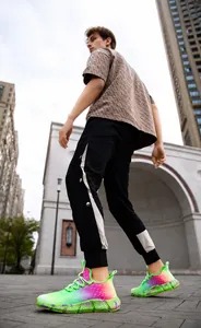Gros plan de baskets dégradées vives avec un jogging à bandes latérales et un tee-shirt