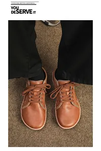 Dettaglio di scarpe barefoot in pelle marrone con punta larga e chiusura con lacci