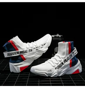Detail view of white high-top knit sneakers with geometric thick soles and red accents