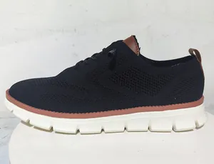 Detail of breathable black knit upper and brown leather accents on men's casual loafer