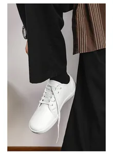 Vista indossata di sneakers bianche in pelle a piedi nudi con design casual stringato