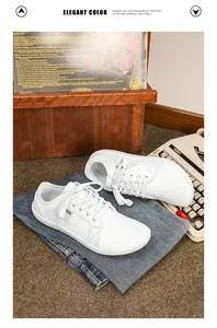 Sneaker barefoot in pelle bianca con jeans in denim e dettaglio decorativo vintage