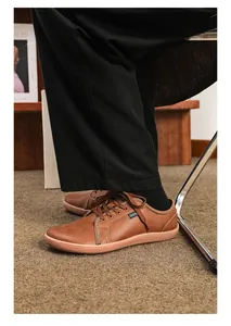 Dettaglio di scarpe a piedi nudi in pelle marrone con etichetta moda sul lato laterale