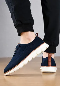Detailansicht dunkelblauer Strick-Sneaker mit braunen Lederakzenten und dicker weißer Sohle