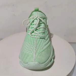 Vue détaillée de la basket en maille vert menthe avec lacets blancs sur support