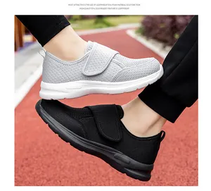 Detail showing breathable mesh fabric and velcro strap on light grey and black sneakers