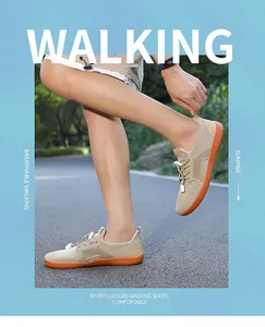 Dettaglio di scarpe da trekking in rete kaki con suola in gomma arancione e coulisse