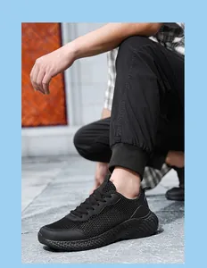 Détail macro du tissu en maille noire respirante et semelle texturée sur chaussures de sport