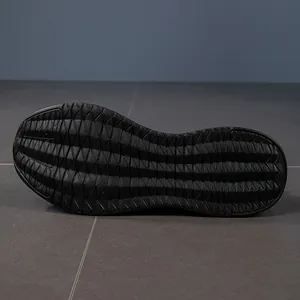 Detail view of the black non-slip rubber outsole with wavy tread patterns on running shoes