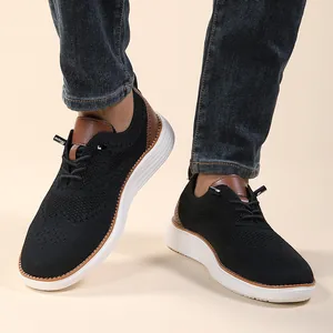 Detail of men's black knit sneakers with brown leather accents and white cushioned sole