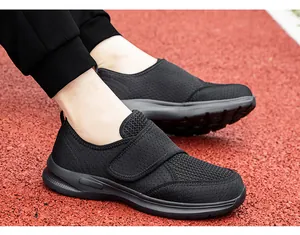Detail view of black breathable mesh walking shoe with velcro strap on a red track
