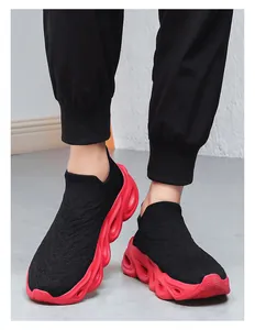 On-foot view of black knit sock sneakers with red hollowed-out wave soles and slip-on design