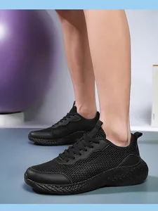 Gros plan de chaussures de course noires en mesh respirant pour hommes à semelle épaisse