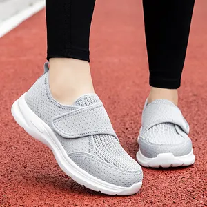 Women's grey breathable mesh sneakers with wide velcro straps on red running track