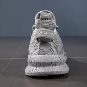 Close-up of gray mesh sneakers showing heel pull tab with DESIGNED 2020 text detail