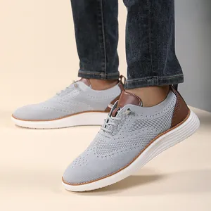 Close-up of gray breathable knit loafer with brown leather accents and white non-slip sole