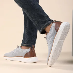 Detail of grey flyknit casual men's shoes with brown leather accents and anti-slip white sole