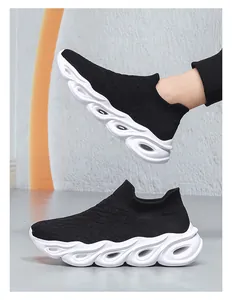 Detail of black knit slip-on sneakers with white wavy hollow shock-absorbing soles