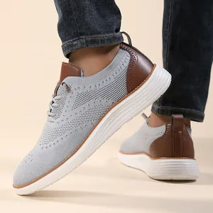 Close-up of light grey breathable knitted casual men loafers with brown leather details