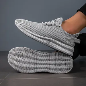 Detail view of breathable grey knit sneakers with textured anti-slip outsoles