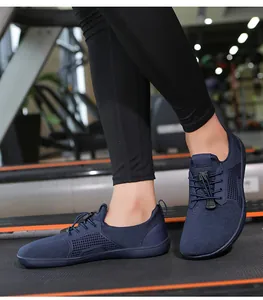 Dettaglio scarpe a piedi nudi blu navy con rete traspirante su un tapis roulant
