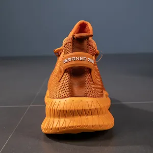 Close-up of orange breathable mesh sneakers featuring heel support and 3D geometric sole