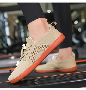 Scarpe a piedi nudi kaki con punta larga e suola arancione su un tapis roulant