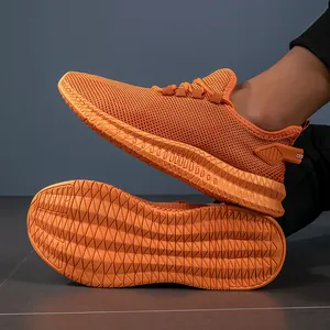 Detail of breathable orange mesh running shoe with thick cushioning and wavy grip sole