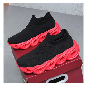 Top view of black breathable knit slip-on sneakers with thick wave red soles