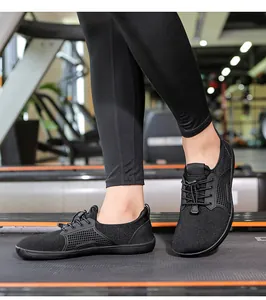 Vista ravvicinata al piede di scarpe barefoot nere su un tapis roulant in palestra