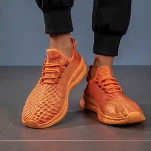 Detailed macro view of orange breathable mesh fabric and wavy textured sole on sport sneaker